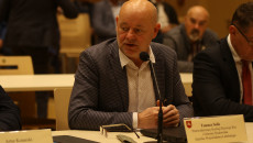 Tomasz Solis siedzi za stołem i przemawia