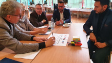 Uczestnicy warsztatów siedzą przy stole i dyskutują