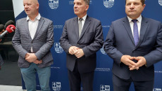 Tomasz Solis, Andrzej Pruś oraz Artur Konarski stoją na tle ścianki z herbem województwa świętokrzyskiego