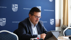 Przewodniczący Waldemar Wrona siedzi przy monitorze