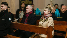 Grupa osób, w tym marszałek Andrzej Bętkowski siedzi w ławach kościelnych