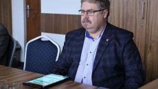 Radny Paweł Krakowiak siedzi przy stole