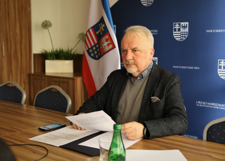 Przewodniczący Grzegorz Banaś Siedzi Przy Stole.
