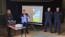 Do Mikrofonu Przemawia Robert Janus, Obok Stoi Dwóch Policjantów I Kobieta