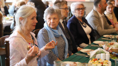 Grupa starszych osób siedzi przy stole