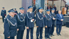 Marszałek Andrzej Bętkowski w mundurze strażackim pozuje do zdjęcia ze strażakami