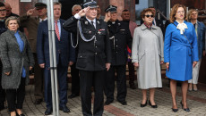 Marszałek Andrzej Bętkowski salutuje w mundurze strażackim. W tle uczestnicy uroczystości