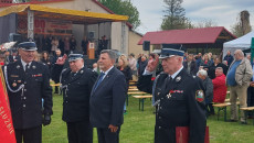 Marszałek Andrzej Bętkowski salutuje w mundurze strażackim podczas uroczystości plenerowej