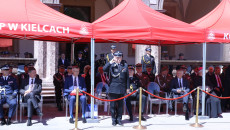Andrzej Bętkowski ubrany w mundur strażacki salutuje stojąc przed uczestnikami wydarzenia