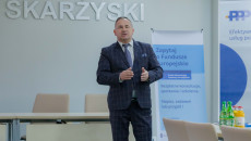 Mężczyzna z mikrofonem w dłoni prowadzi szkolenie