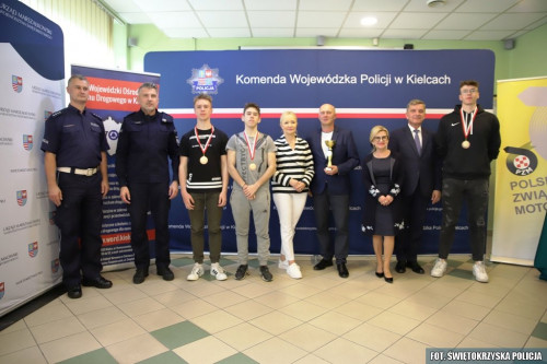 Andrzej Pruś Pozuje Do Zdjęcia Z Policjantami, Dyrektorką Wojewódzkiego Ośrodka Ruchu Drogowego Oraz Zwycieżcami W Konkursie