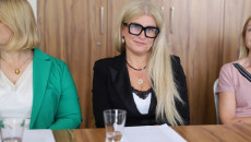 Kobieta Ubrana W Czarny żakiet Siedzi Przy Stole W Sali Obrad
